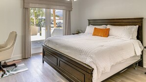 A bedroom with a large bed, a chair, a ceiling fan, and a view of the outdoors. - Fish, Swim & Boat: Riverfront Port Charlotte Home (Port Charlotte)