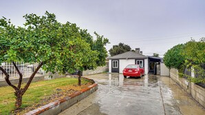 A residential street with a red car parked in front of a house. - Explore LA & Long Beach: Compton Condo w/ Patio (Compton)