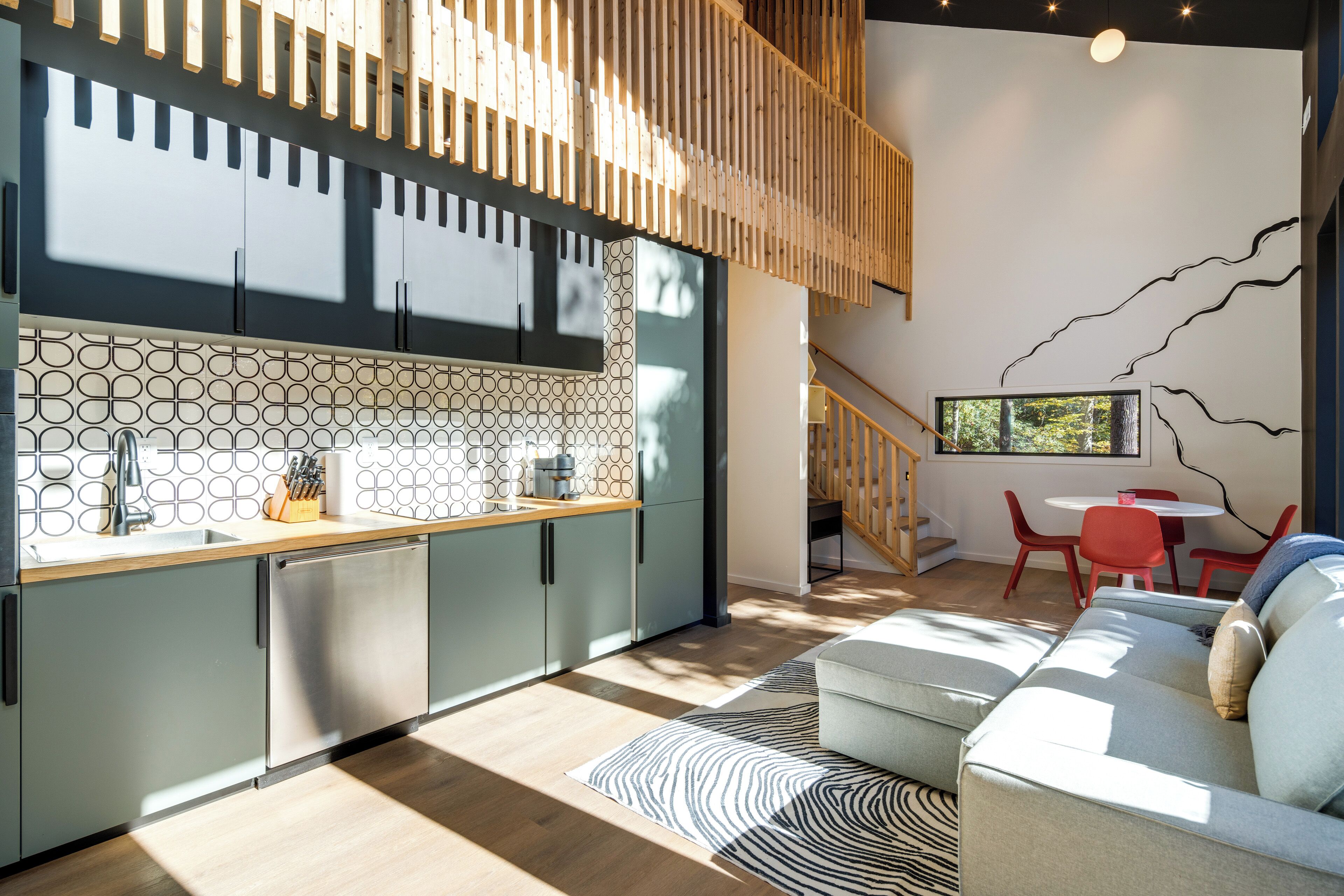 Une cuisine moderne avec un plafond en bois, des armoires grises et un pare-feu décoré.