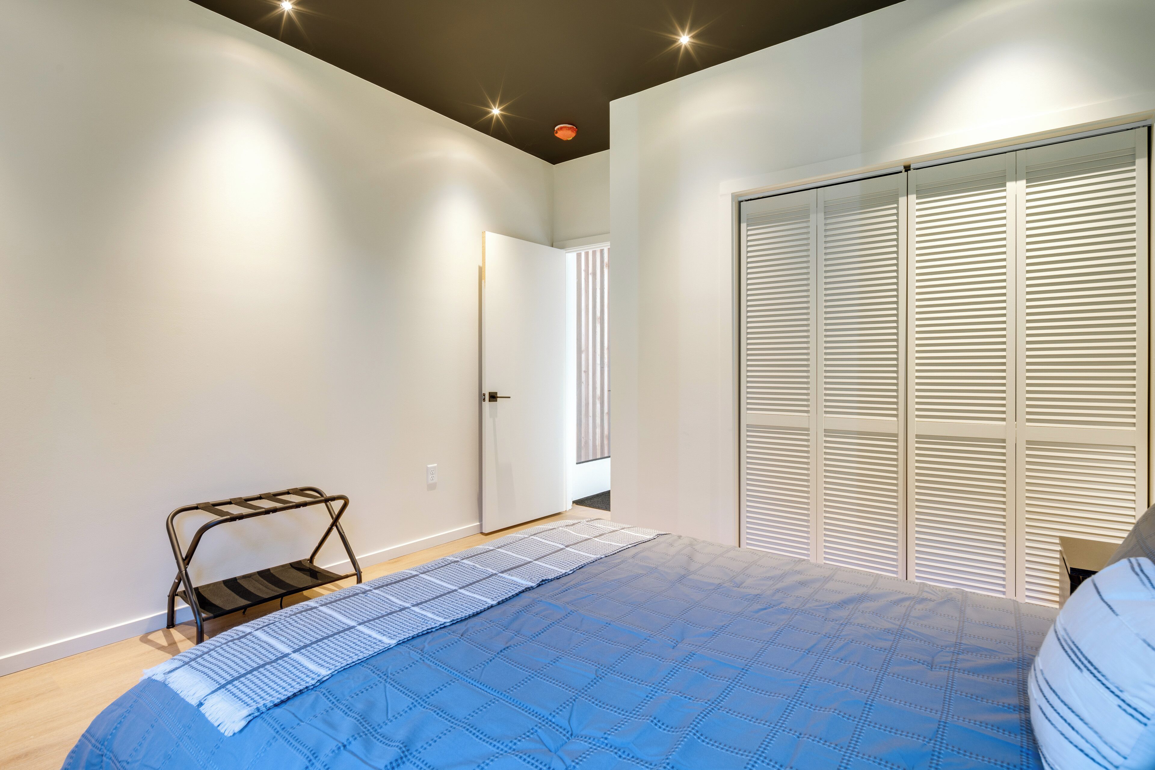 Une chambre à coucher avec un lit, une armoire et une petite table.