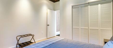 Une chambre à coucher avec un lit, une armoire et une petite table.