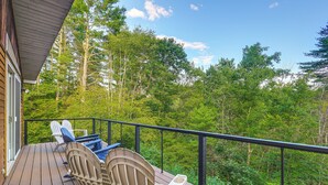 A wooden deck with Adirondack chairs and a railing overlooking a forested area. - 9 Mi to Hickory Ski Center: Wooded Warrensburg Gem (Warrensburg)