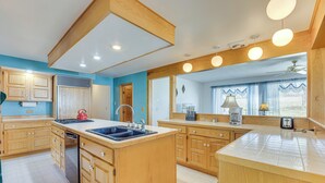 A spacious kitchen with wooden cabinets, a large island with a sink, and a ceiling fan. - Mtn-view Colorado Haven! 32 Mi to Royal Gorge Park (Cotopaxi)