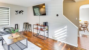 Una sala de estar con televisor, una mesa de centro, una planta y una estantería.