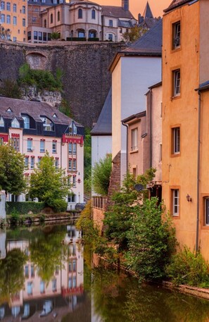 Ein Kanal, an dessen Seite Gebäude und auf der anderen eine Klippe stehen.