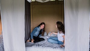 A single bed with patterned bedding and a canopy. - Camping Gritt - De Lodge (Erpeldange-sur-Sûre)