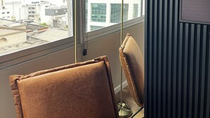 A room with a large window, a floor lamp, and a brown chair. - Design apartment in historic district with river view (Montevideo)