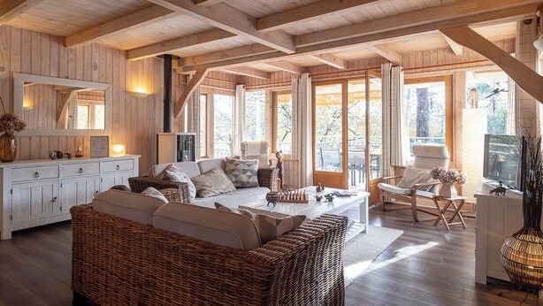 A cozy wooden interior with a sofa, chairs, and a dining area. - Charming all-wood villa with heated pool -4 bedrooms -3 bathrooms (Biscarrosse)