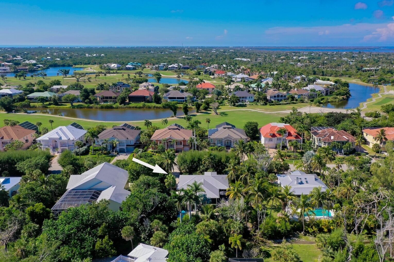 Un quartier résidentiel avec des maisons, un lac et un terrain de golf.