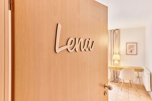 Una puerta de madera con una placa que dice "Lena".