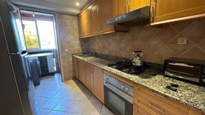 Eine Küche mit Holzausstattung, Granitarbeitsplatten, einem Herd, einem Backofen und einem Toaster.