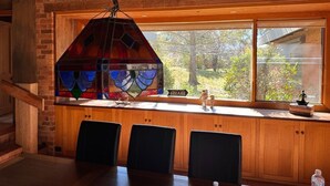 A dining area with a stained glass window, wooden cabinets, and a view of the outdoors. - Country Homestead in Avenel (Avenel)