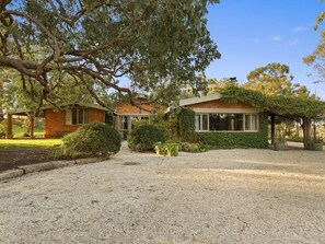 A house with a gravel driveway, a brick exterior, and a covered porch area. - Country Homestead in Avenel (Avenel)