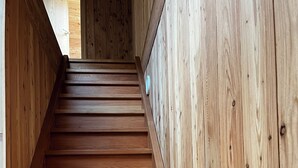 Eine Holztreppe mit Geländer, die nach oben führt.