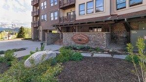 Un immeuble à plusieurs étages, doté d’une façade en pierre, de balcons et d’une enseigne indiquant « Black Bear Lodge ».