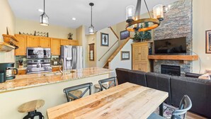 A modern kitchen with wooden cabinets, stainless steel appliances, and a large island with seating. - Cozy Mountain Hideaway in Keystone — Relax in Peace, Ski in Minutes! (Keystone)