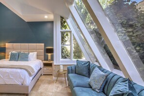 A bedroom with a bed, a nightstand, a sofa, and a window with a view of trees. - 5700 sqft Lux Golf Villa w Pool & Spa Near Strip (Henderson)