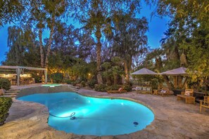 A pool area with a hot tub, lounge chairs, and umbrellas. - 5700 sqft Lux Golf Villa w Pool & Spa Near Strip (Henderson)