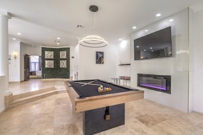 A pool table in a modern room with a fireplace and a large TV. - 5700 sqft Lux Golf Villa w Pool & Spa Near Strip (Henderson)