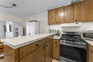 Una cocina moderna con armarios de madera, una estufa de acero inoxidable y un microondas.