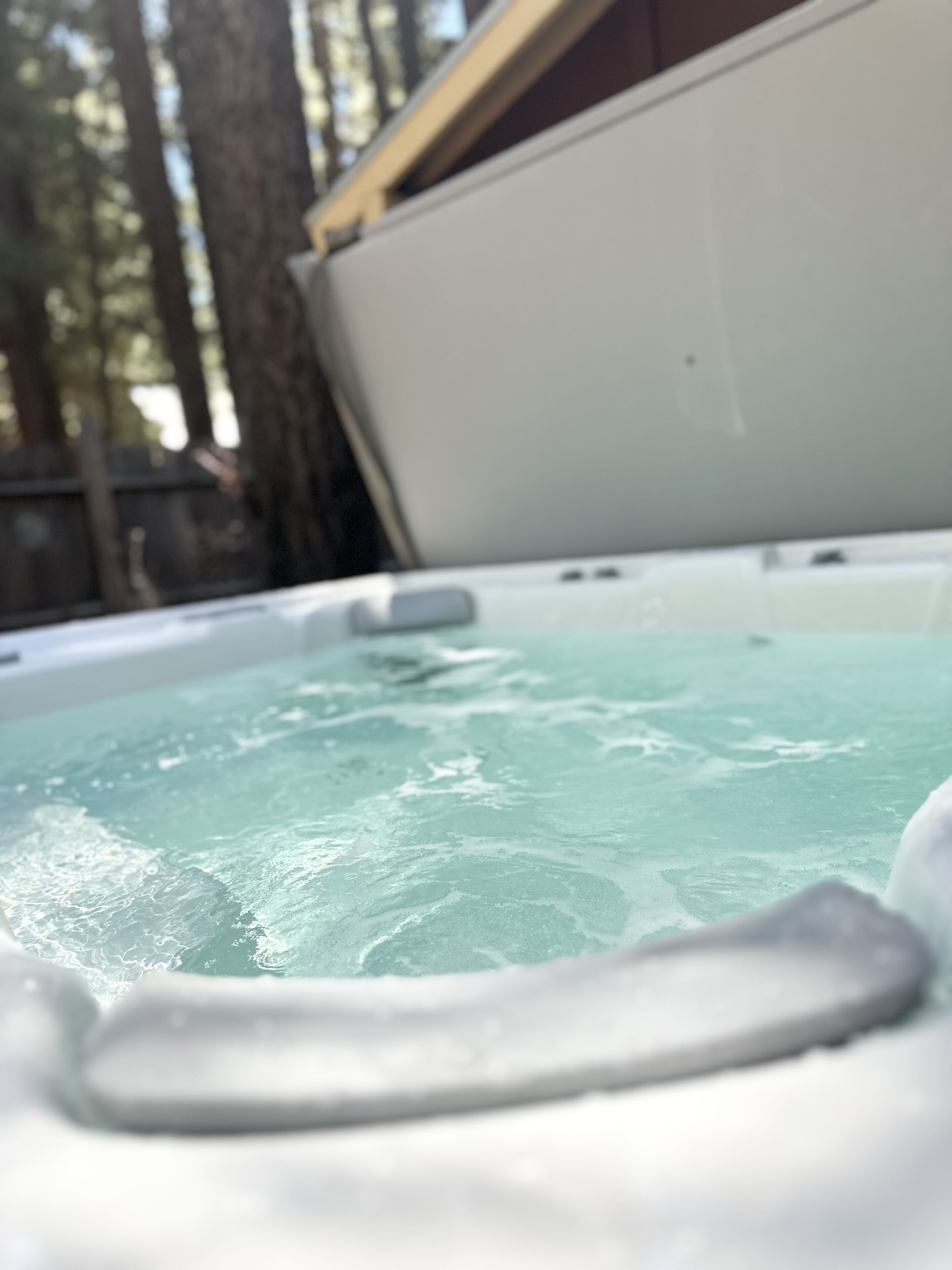 A hot tub with a view of trees in the background.