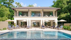 A two-story house with a swimming pool, outdoor seating, and a garden. - Sea Grove House 5 Bedroom Villa (Weston)