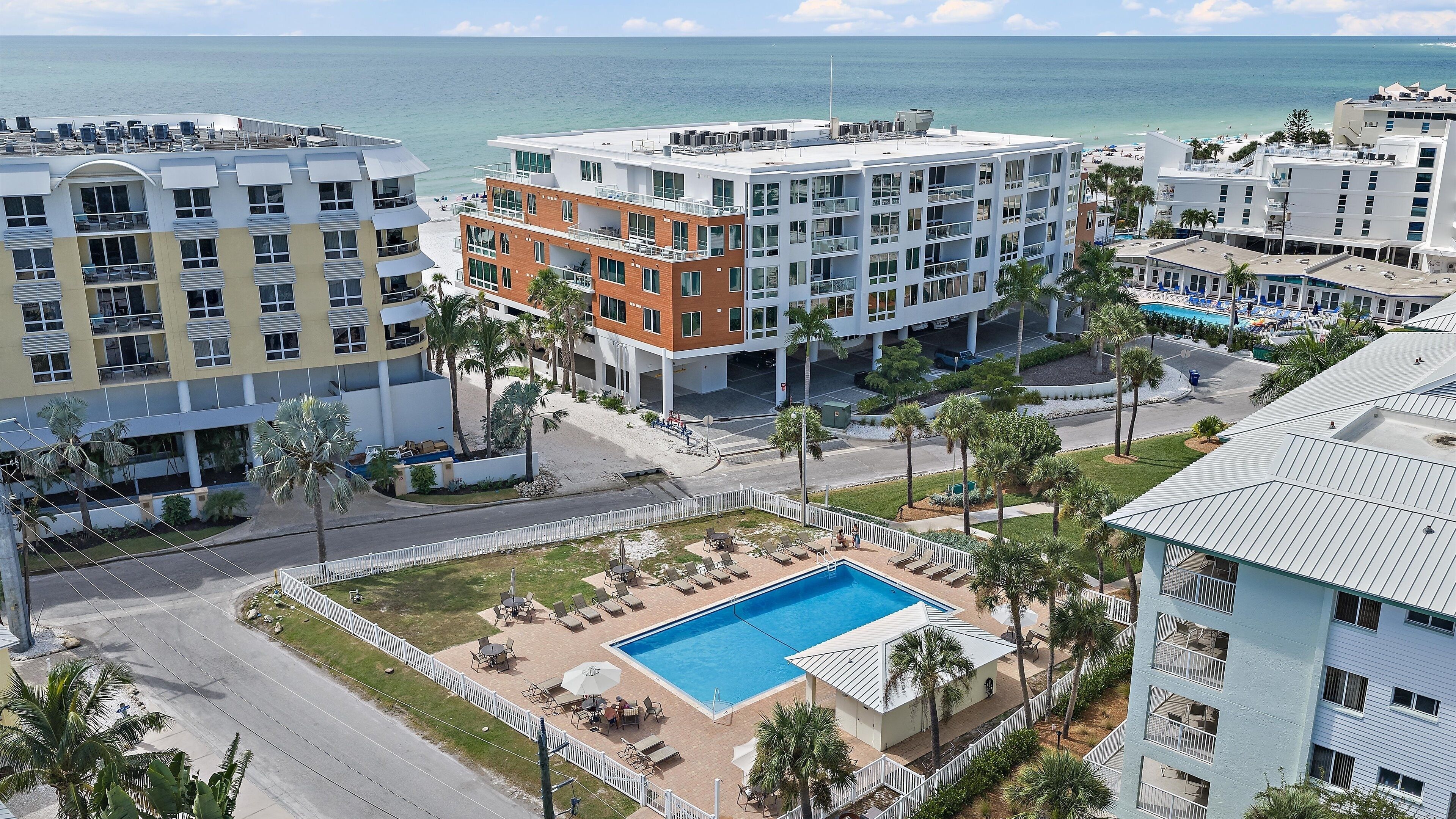 A hotel with a pool, multiple floors, and a view of the beach.