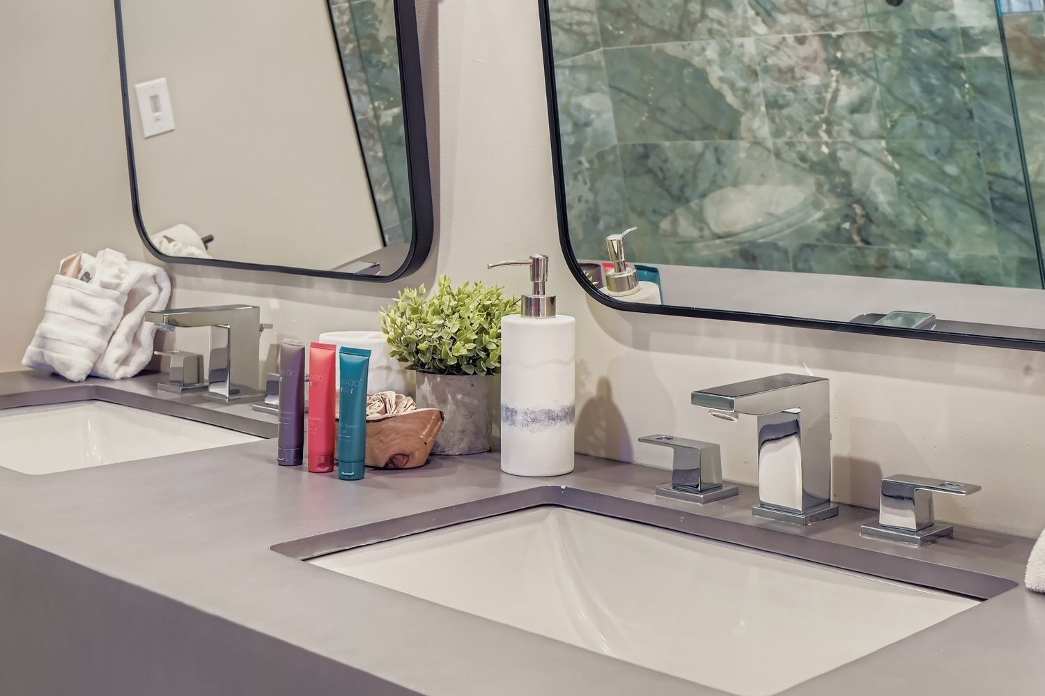 A bathroom with two sinks, a mirror, and toiletries.