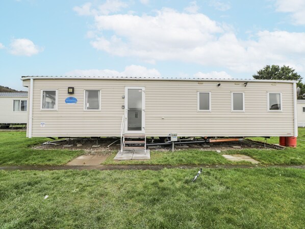 A mobile home with a small porch, a door, and a window. - Brynowen Holiday Park - 22432 (Borth)