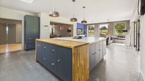 A modern kitchen with a central island, pendant lighting, and a view to the outdoors.