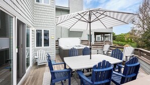 An outdoor deck with a table and chairs, a hot tub, and a large umbrella. - Villa in Corolla Light with Views, Hot Tub & More! (Corolla)