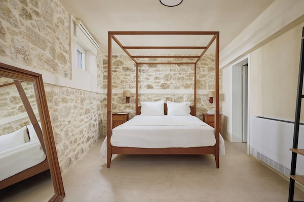 romantic master with a four-poster bed & stunning stone walls, a serene retreat