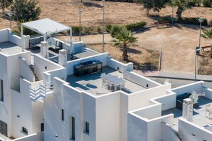 Ein modernes Gebäude mit Dachterrasse, Sitzgelegenheiten im Freien und Grillplatz.