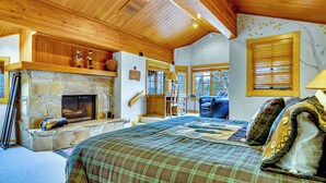 A cozy room with a stone fireplace, wooden ceiling, and a bed with a plaid blanket. - CURRENTLY BEING REMODELED FOR THE 2026/2027 SEASON! NEW PHOTOS COMING SOON! (Deer Valley)