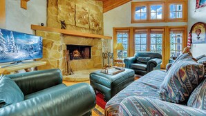 A cozy living room with a stone fireplace, leather sofas, and a television. - CURRENTLY BEING REMODELED FOR THE 2026/2027 SEASON! NEW PHOTOS COMING SOON! (Deer Valley)