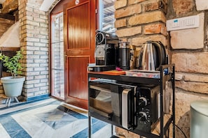 A kitchen area with a built-in oven, a coffee machine, and a kettle on a countertop. - Nature Lodge With Sauna and Hot Tub (Vidovec)