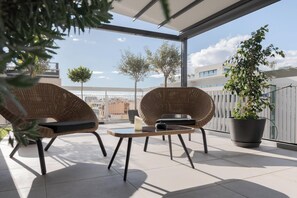 A balcony with wicker chairs, a table, and a potted plant. - Athens Golden Light Premium Residence, Bill & John Apartments & Villas (Athens)