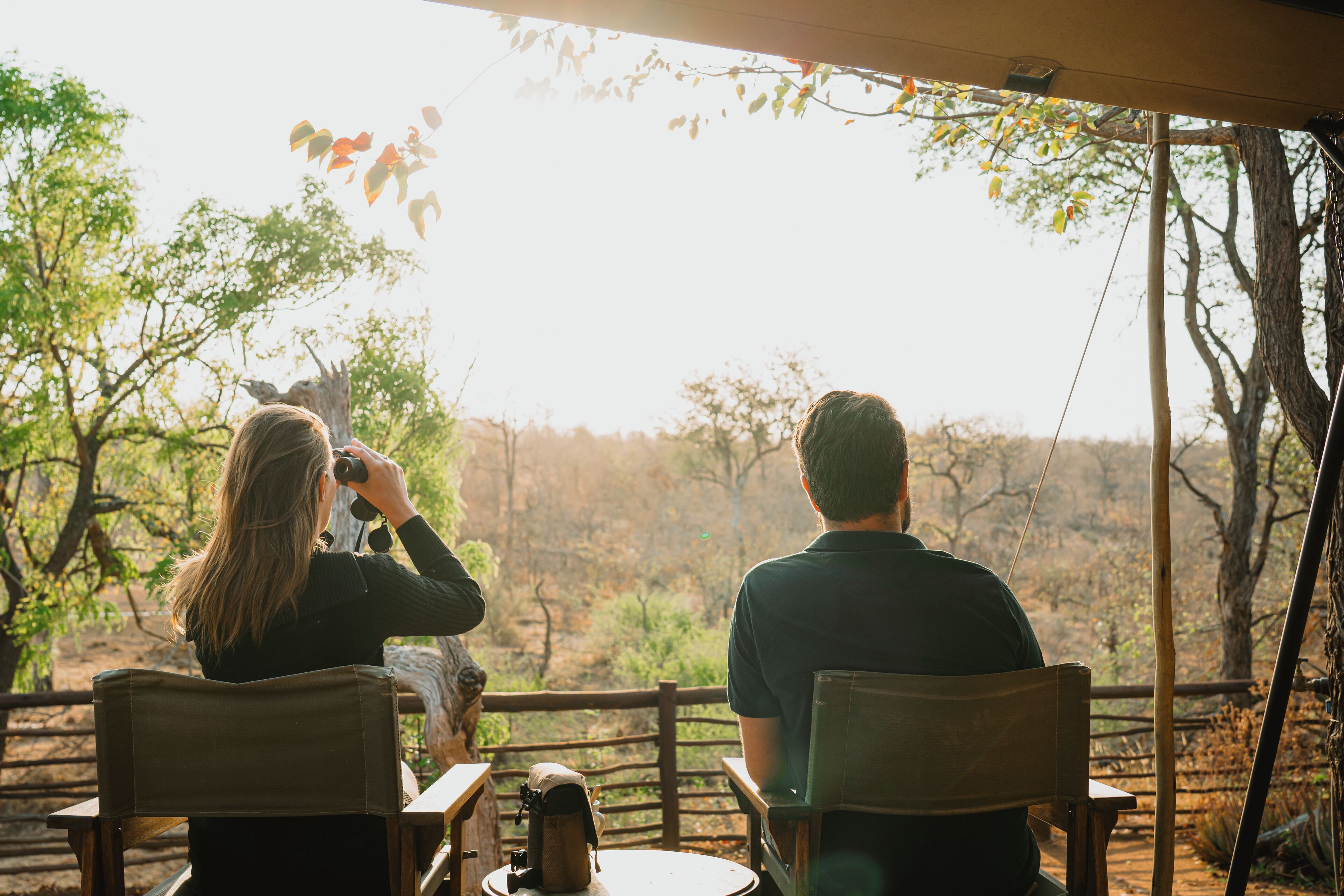 Two people seated at a table with a view of a natural landscape.