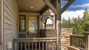 A wooden porch with a stone wall and a metal railing. - Kicking Horse Buckskin 3-205 Family friendly 2 bed private deck & mountain views (Granby)