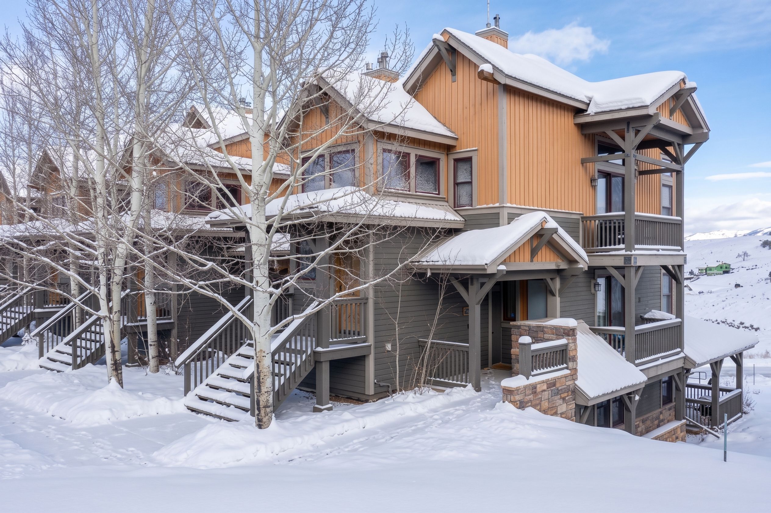 A multi-story wooden building with a balcony and a staircase leading to the entrance.
