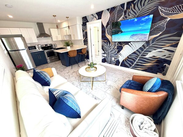 Un espace de vie moderne comprenant un canapé, un fauteuil et une table basse.