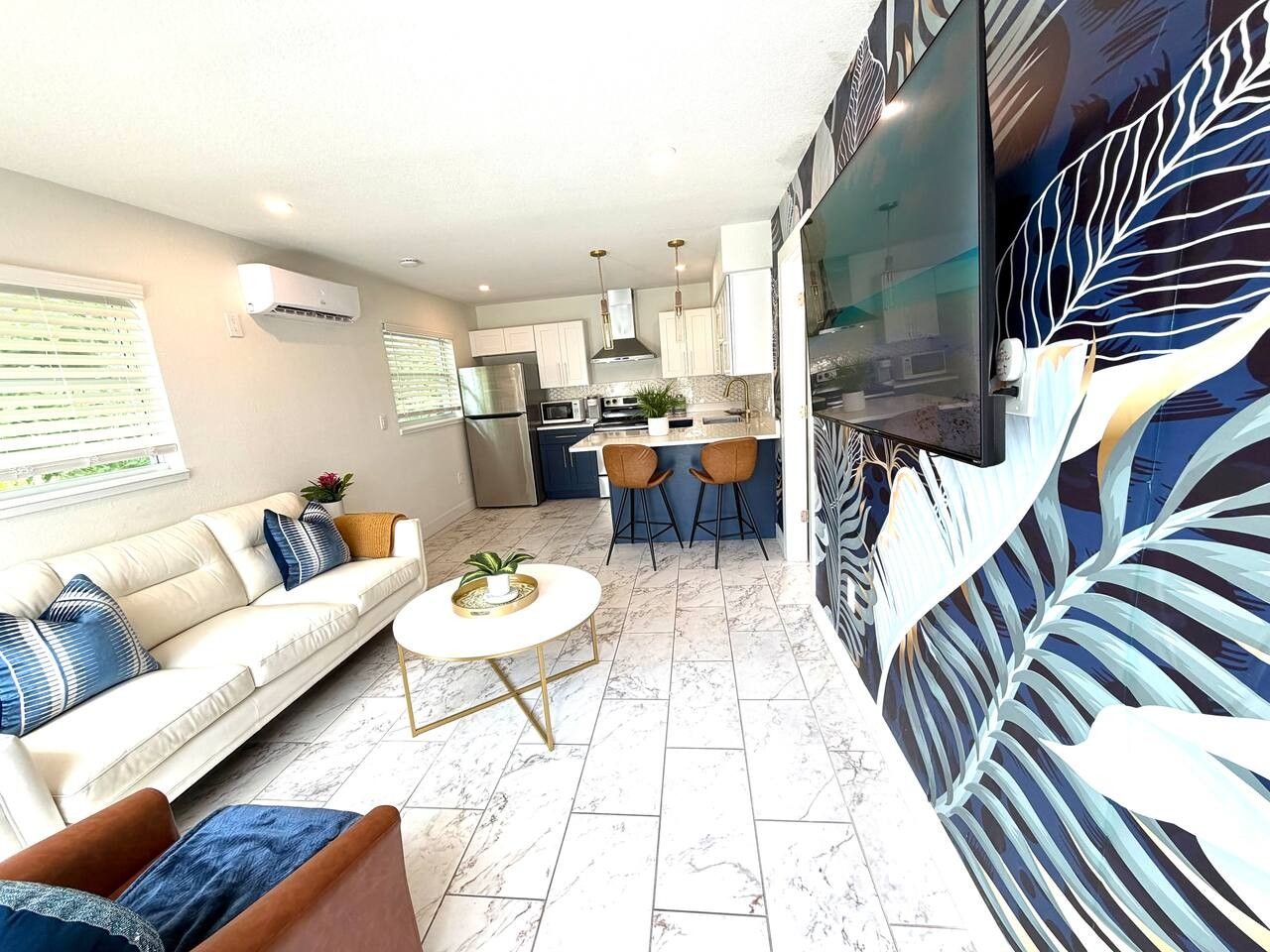 A modern living room with a sofa, coffee table, and a dining area with chairs.