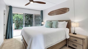 Ein Schlafzimmer mit Bett, Nachttisch und Deckenventilator.
