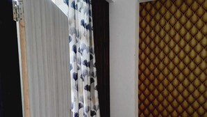 A room with a sliding door, a patterned curtain, and a textured wall. - Elegant 3-bedroom apartment in Rajawas (Rajawas)