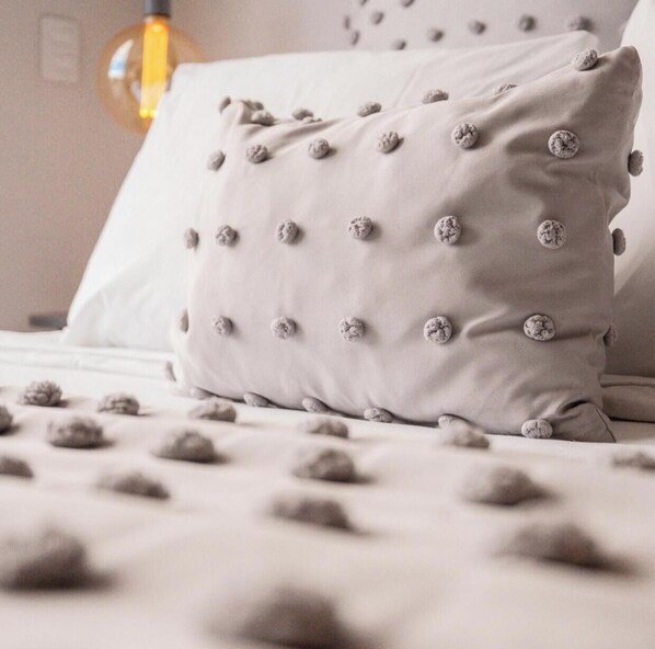 Un coussin dont la surface est texturée et ornée d’un motif de motifs circulaires en creux.