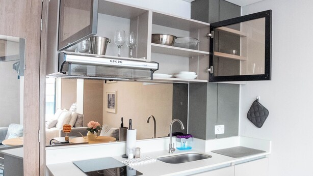 Eine moderne Küche mit Einbauherd, Spüle und einem Schrank mit Glastüren.