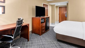 A hotel room with a bed, desk, chair, television, and a minibar. - Prime Baton Rouge Location Near LSU Museum, Zoo, and Riverfront Dining (Baton Rouge)