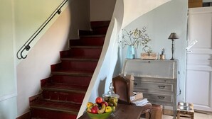 A staircase with a wooden handrail leading to a landing. A wooden table with a bowl of fruit is placed on the landing. - Vacqueyras: Mas L'Epicure - bright apartment with shared pool and garden (Vacqueyras)