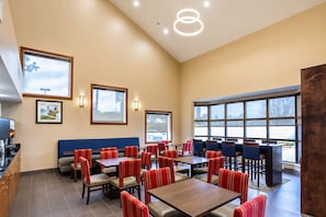 A hotel dining area with tables and chairs, large windows, and framed pictures on the walls. - 2 Convenient Units w/ Breafast | Near LSU, Zoo & Mall of Louisiana & I-10 Access (Baton Rouge)
