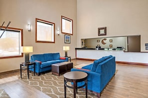 A hotel lobby with blue sofas, a reception desk, and a large window. - 2 Convenient Units w/ Breafast | Near LSU, Zoo & Mall of Louisiana & I-10 Access (Baton Rouge)